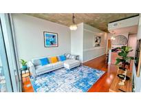 Bright living room with a modern sofa, blue accent rug, and neutral walls at 860 Peachtree Ne St # 1411, Atlanta, GA 30308