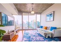 Bright living room with hardwood floors, cityscape views, and modern furnishings at 860 Peachtree Ne St # 1411, Atlanta, GA 30308