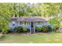 Charming single-story home with a welcoming front porch and a beautifully landscaped front yard at 6595 Oakwood Dr, Douglasville, GA 30135