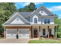 Beautiful two-story home featuring stone accents, a two-car garage, and a welcoming front porch at 209 Wildwood Way, Canton, GA 30114