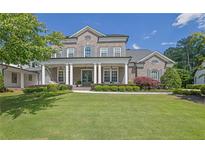 Stunning two-story brick home with a manicured lawn and a welcoming front porch with stately columns at 3264 Andante Ne Dr, Marietta, GA 30062
