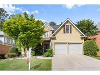 Charming two-story home featuring a manicured lawn and a stone-accented facade with a two car garage at 4085 Tritt Homestead Dr, Marietta, GA 30062