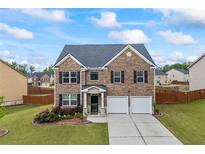 Beautiful two-story brick home featuring a two-car garage, manicured lawn, and inviting curb appeal at 548 Azalea Bloom Drive E, Loganville, GA 30052