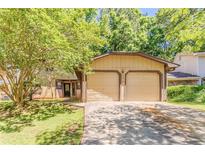 Inviting exterior view of home with a two-car garage and mature landscaping at 1074 Cherokee Hts, Stone Mountain, GA 30083