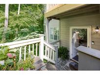 Charming home exterior featuring a porch entrance with lush greenery surroundings and a wooden railing at 301 Mill Pond Se Ct, Smyrna, GA 30082