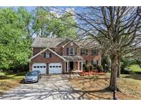 Traditional two-story brick home featuring a two-car garage, manicured landscaping, and a long driveway at 531 Chadborn Ct, Lawrenceville, GA 30045