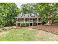 Charming brick home with a well-manicured lawn, mature trees, and a welcoming front porch at 4314 Arbor Bridge Ct, Marietta, GA 30066
