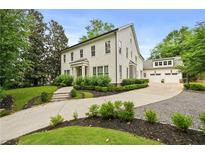 Stunning two-story home featuring a manicured lawn and a long driveway leading to a spacious three-car garage at 4015 Wieuca Ne Rd, Atlanta, GA 30342