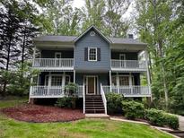 Charming two-story home featuring double balconies, a landscaped front yard, and inviting curb appeal at 5307 Red Rock Trce, Powder Springs, GA 30127