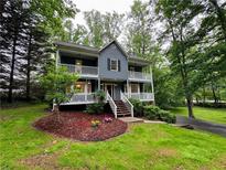 Charming two-story home featuring double balconies and a lush, green lawn with mature trees at 5307 Red Rock Trce, Powder Springs, GA 30127