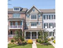 Charming townhome with a well-manicured lawn, inviting covered porch, and appealing architectural details at 281 Cherokee Ne St, Marietta, GA 30060