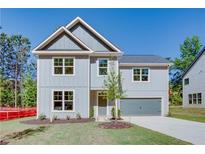 Charming two-story home with gray siding, attached garage, and well manicured lawn on a sunny day at 3352 Landings South Dr, Atlanta, GA 30331