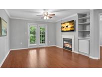 Bright living room featuring hardwood floors, fireplace, built-ins, and french doors at 3655 Habersham Ne Rd # 244B, Atlanta, GA 30305