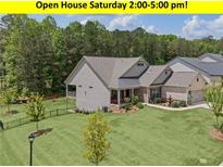 Charming two-story home featuring a manicured lawn, covered porch, and fenced backyard at 438 Southland Cir, Canton, GA 30115