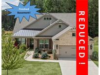 Charming home with manicured lawn, fountain, neutral brick, and attached garage is now REDUCED at 438 Southland Cir, Canton, GA 30115