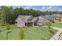 Charming single-story home featuring a beautifully landscaped lawn, a fountain, and inviting front porch seating at 438 Southland Cir, Canton, GA 30115