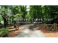 Long driveway with gated entrance leads to a wooded property at 116 Woolsey Creek Trail, Fayetteville, Georgia at 116 Woolsey Creek Trl, Fayetteville, GA 30215