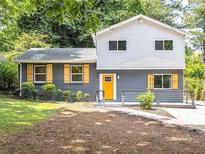 Charming two-story home with a freshly painted exterior, bright yellow door and updated shutters at 2247 Green Forrest Dr, Decatur, GA 30032