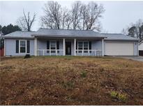Charming single-story home with a covered front porch and attached garage at 563 Fieldgreen Dr, Jonesboro, GA 30238