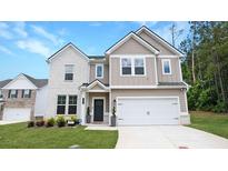 Beautiful two-story home with a manicured lawn, attached two car garage, and appealing neutral color palette at 20 Geranium Ln, Covington, GA 30016