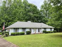 Charming single-story home with a well-maintained lawn and mature trees providing ample shade at 235 Creekside Way, Mcdonough, GA 30252