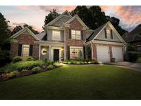 Charming two-story home with brick accents, manicured lawn, and lush landscaping at 4170 Haynes Mill Nw Ct, Kennesaw, GA 30144