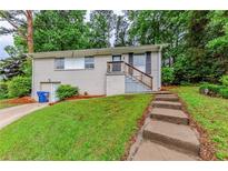 Charming home featuring a brick facade, landscaped front yard and stairway leading to the main entry at 3197 Ward Sw Dr, Atlanta, GA 30354