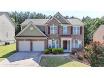 Charming two-story brick home featuring a two-car garage and well-manicured front yard at 645 Earlham Dr, Suwanee, GA 30024