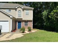 Charming two-story home features a blue front door, partial brick facade, and a well-manicured lawn at 3753 Soapstone Rd, Decatur, GA 30034