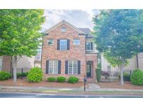 Charming two-story brick home with a well-manicured front yard and black shutters at 4448 Tacoma Trce, Suwanee, GA 30024