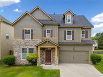 Two-story home boasts a stone facade, muted siding, and a well-manicured lawn at 4920 Fourth Rail Ln, Cumming, GA 30040