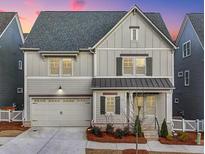 Charming two-story home with gray siding, well-manicured landscaping and a two car garage at 1006 Fendley St, Woodstock, GA 30188