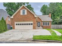 Charming brick home features an attached garage, well-maintained lawn, and inviting front entrance at 1523 Pangborn Station Dr, Decatur, GA 30033