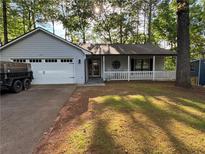 Charming home featuring a covered porch with white railings and a convenient attached two-car garage at 4771 Pinefield Nw Dr, Acworth, GA 30102