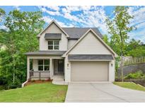Charming two-story home featuring a covered porch, attached garage, and professionally landscaped yard at 216 Creek View Pl, Canton, GA 30114