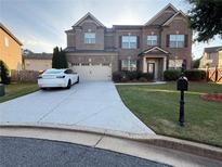 Beautiful two-story brick home with a well-maintained lawn and long driveway at 3670 Kissell Dr, Cumming, GA 30041