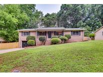 Charming brick home with a well-maintained front yard and mature trees at 3916 Green Forest Se Ln, Smyrna, GA 30082