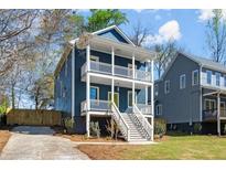 Charming two-story home featuring a double front porch, steps to the entry, and beautiful landscaping at 1183 Mobile Nw St, Atlanta, GA 30314