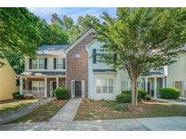 Charming townhome with a brick facade, well-manicured lawn, and inviting front porch, perfect for relaxing outdoors at 2735 Snapfinger Mnr, Decatur, GA 30035