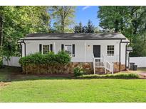 Charming renovated home with stone foundation, white picket fence, and fresh landscaping at 2849 Knotty Pine Ct, Buford, GA 30519