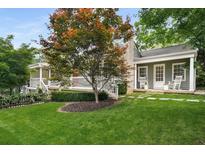 Charming home with a well-manicured lawn, mature tree, and a cozy front porch with rocking chairs at 132 East Ne Dr, Atlanta, GA 30305