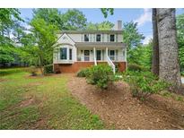 Charming two-story home with a brick foundation, a well-manicured lawn, and mature trees at 3306 Emory Dr, Marietta, GA 30062