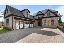 Stunning stone home featuring a three-car garage and a paved driveway, perfect for luxury living at 4253 Biltmore Pl, Marietta, GA 30062