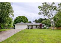 Charming single-story home featuring a well-manicured lawn and an attached two-car garage at 7925 Silversmith Dr, Cumming, GA 30028
