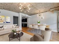 Bright living room features an open floor plan, hardwood floors, and exposed concrete ceiling at 890 Memorial Se Dr # 105, Atlanta, GA 30316