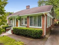 Charming brick home with a welcoming entrance, manicured hedges, and beautiful stained glass windows at 239 Kings Hwy, Decatur, GA 30030