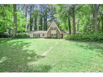 Charming single-Gathering home boasts a stone front facade, lush greenery, and a well-manicured front yard at 2820 Georgian Ter, Marietta, GA 30068