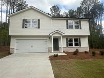 Charming two-story home with a two-car garage, featuring a well-manicured lawn and inviting curb appeal at 75 Emerald Ln, Covington, GA 30014