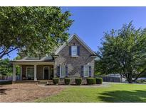 Charming brick home with well-maintained landscaping and a covered front porch at 1892 Raven Hill Ne Dr, Atlanta, GA 30319