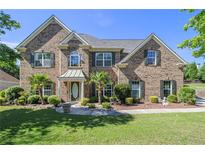 Beautiful two-story brick home with manicured lawn, mature trees and a welcoming front porch at 4765 Smokestone Dr, Douglasville, GA 30135